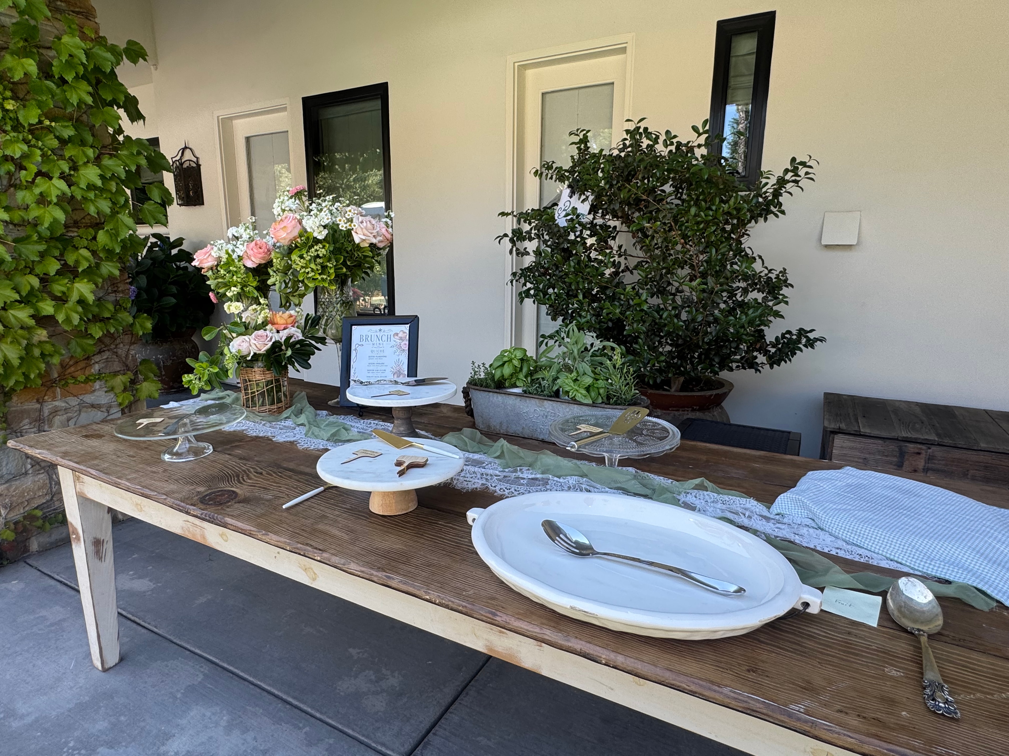 Brunch buffet table with lace runner, cake stands, and florals